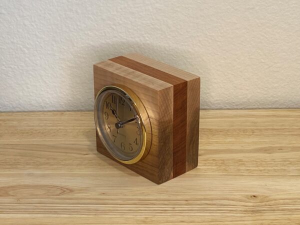 Curly Cube Clock: a small handmade wood clock from the Pacific Northwest, made from exquisite hand-selected hardwoods, a rustic modern, unique gift for any décor, holiday, or occasion. Arabic numeral design with reliable quartz movement. Side view.
